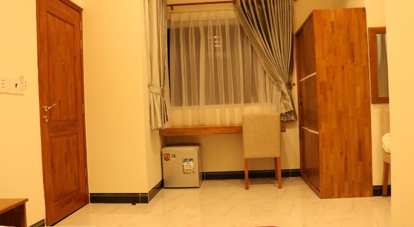 a small room with a door open and a bed in it, Hoang Phuc Hotel in Bình Dương