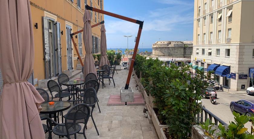 a patio area with chairs, tables and umbrellas, 7 Bell's House in Civitavecchia