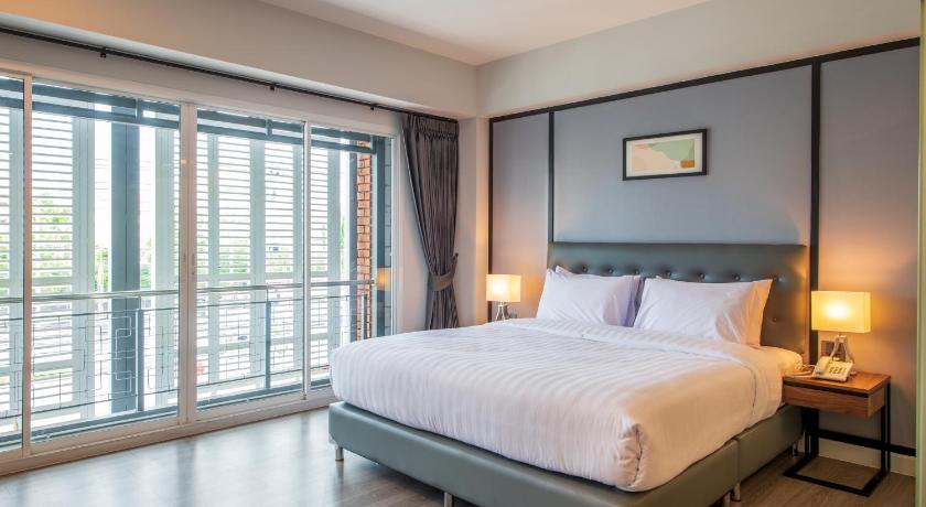 a bedroom with a large bed and a large window, Mayson Place (SHA Extra Plus) in Samut Prakan