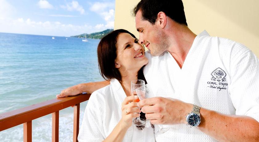 a man and woman kissing on a beach, Coral Strand Smart Choice Hotel in Seychelles Islands