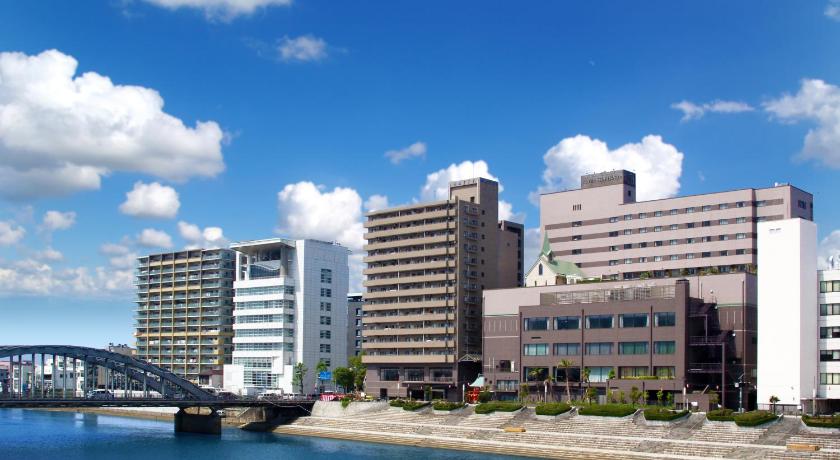 a bridge over a body of water with tall buildings, Numazu Riverside Hotel in Gotemba
