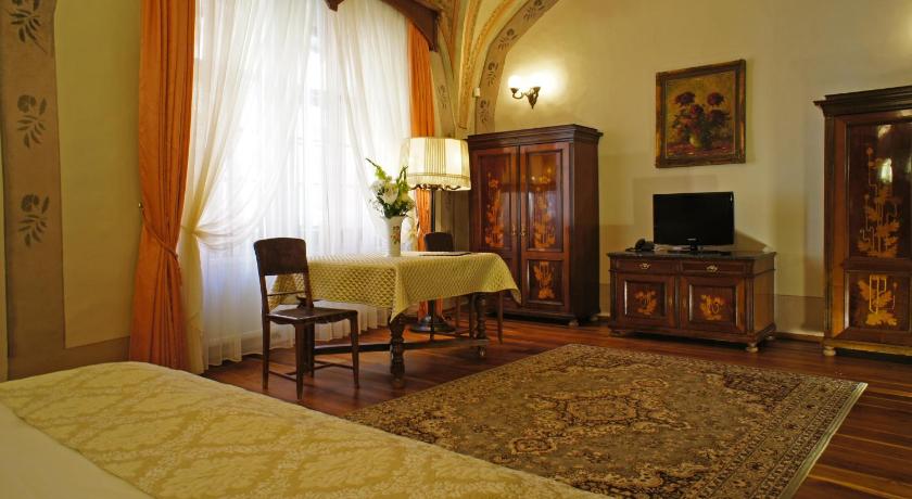 a living room filled with furniture and a tv, Grand Hotel Praha in Prague