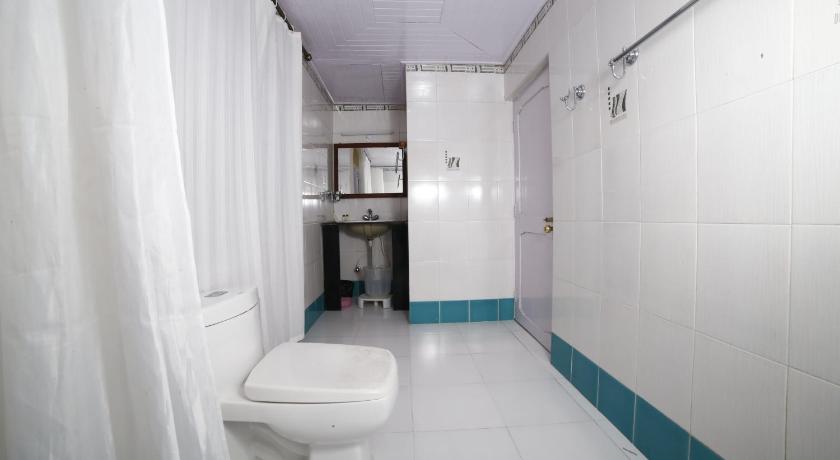 a white toilet sitting in a bathroom next to a sink, Yanthang Dzimkha Resort in Pelling