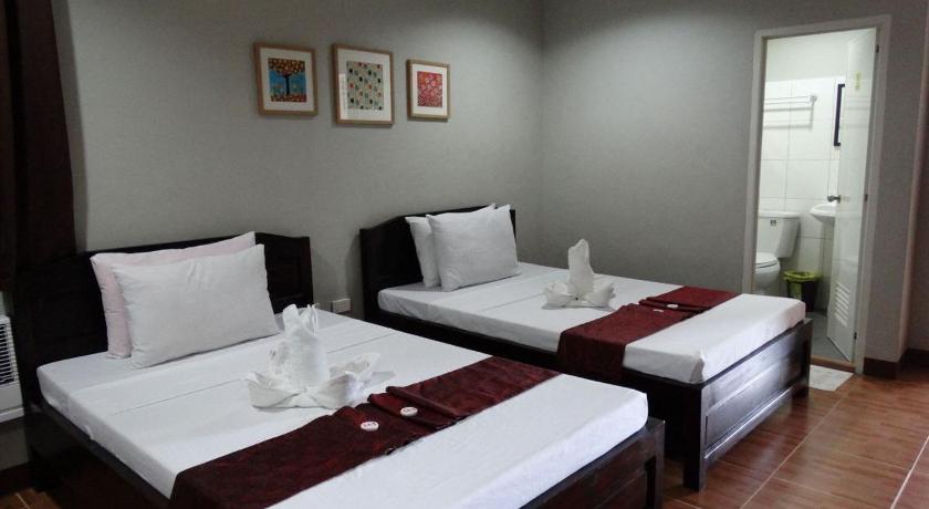 a hotel room with two beds and two lamps, Harbour Gardens Tourist Inn in Bohol