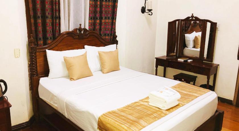 a hotel room with a bed and two lamps, My Vigan Home Hotel in Ilocos Sur