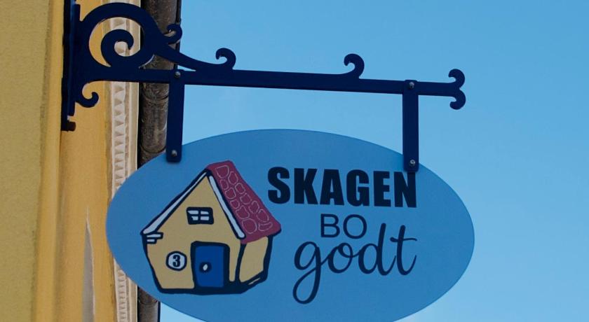 a sign on a building with a cartoon character on it, Skagen Bo Godt Kirkevej in Skagen
