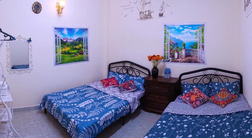 a bedroom with two beds and a painting on the wall, An Nhien House in Dalat