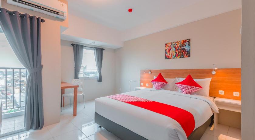 a bedroom with a large bed and a large window, OYO Flagship 750 Mont Blanc in Bekasi