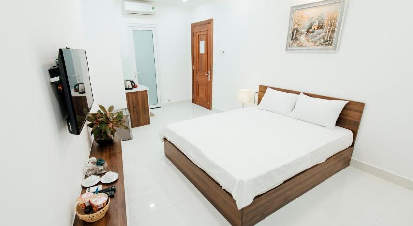 a hotel room with a bed and a tv, Aladdin Hotel in Ho Chi Minh City