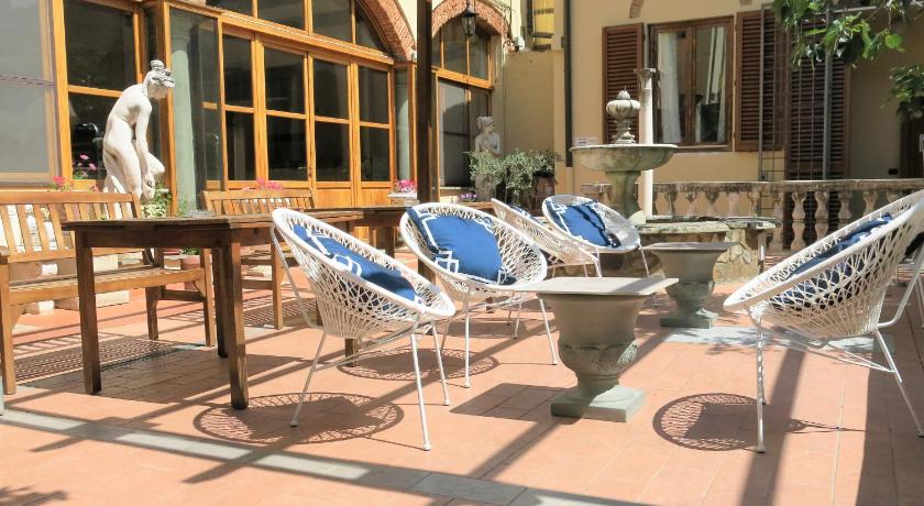 a patio area with chairs, tables and umbrellas, Hostel Archi Rossi in Florence
