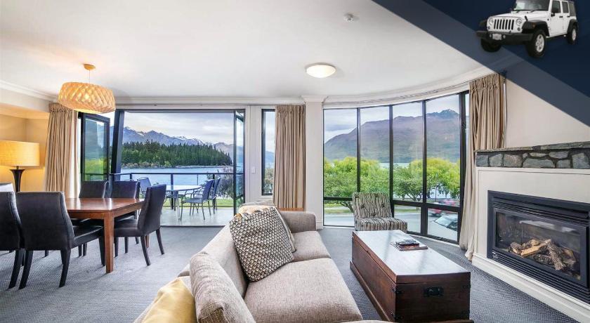 a living room filled with furniture and a fire place, Peppers Beacon Queenstown in Queenstown