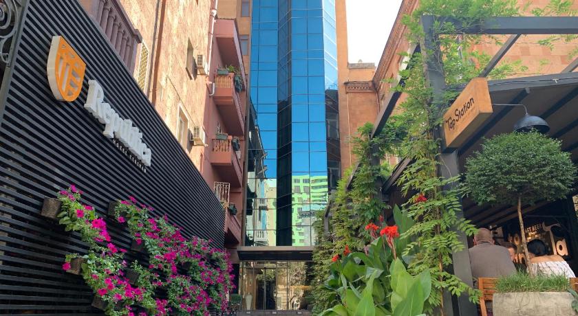 a street with a bunch of flowers in front of a building, Republica Hotel Yerevan in Yerevan