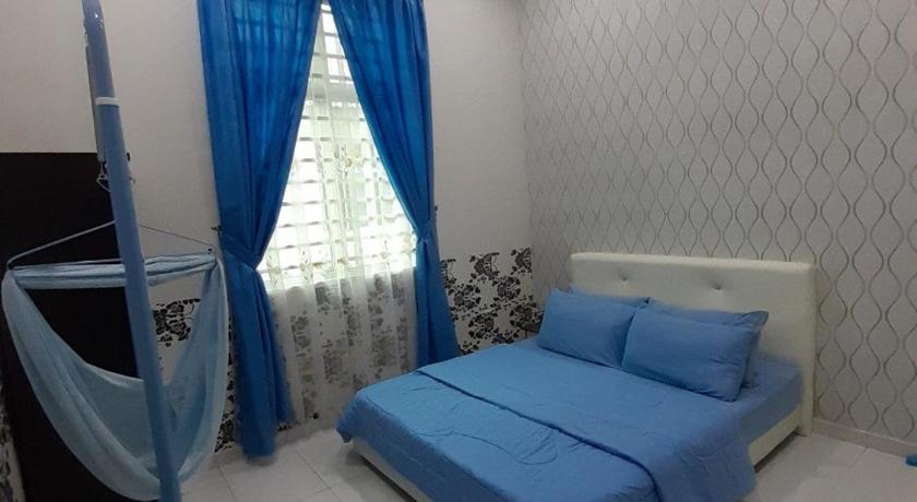 a bedroom with a blue bed and blue walls, Selesa Indah Guest House Melaka - Near City Centre in Malacca