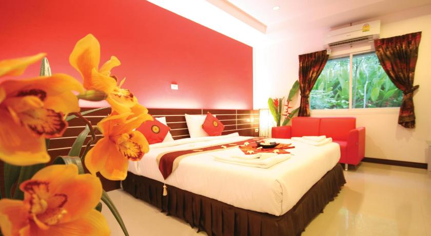 a hotel room with a bed, table, and flowers, Pantharee Resort (SHA Extra Plus) in Krabi