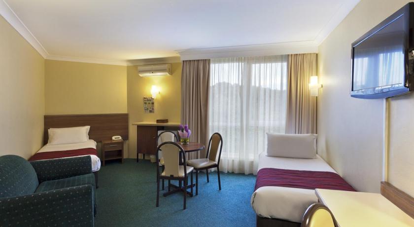a hotel room with two beds and a television, Alpine Motor Inn in Blue Mountains