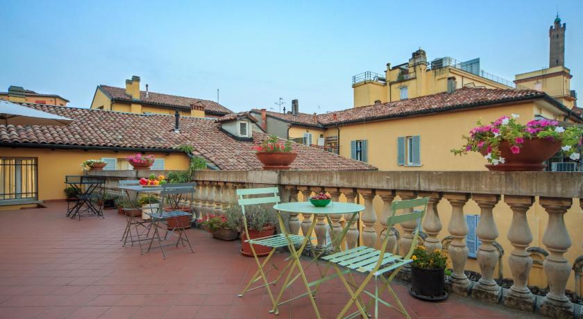 a patio area with tables, chairs and umbrellas, Residence Studio Vita in Bologna
