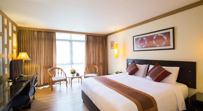 a hotel room with a large bed and a large window, The Tarntawan Hotel Surawong Bangkok in Bangkok