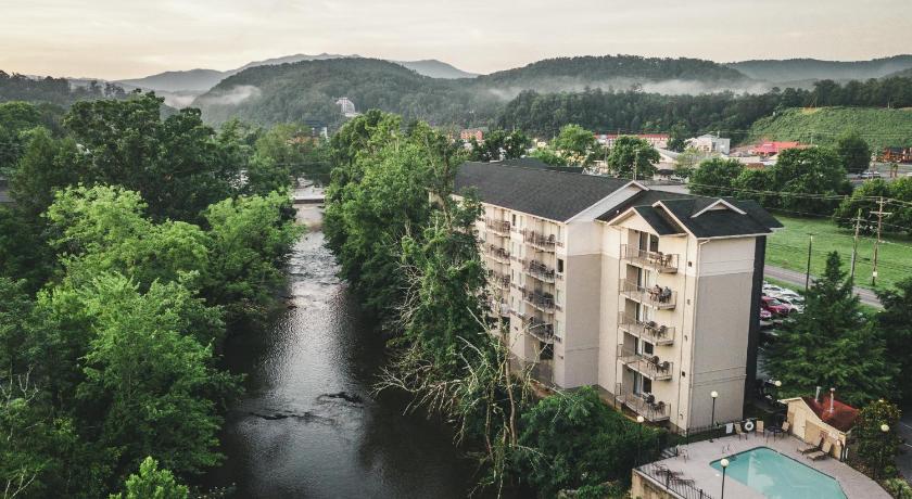 a large building with a river and trees, Twin Mountain Inn & Suites in Pigeon Forge (TN)