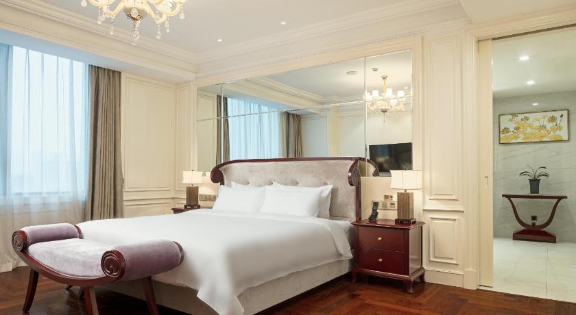 a hotel room with a bed and a dresser, Gallery F Hotel in Wuhan
