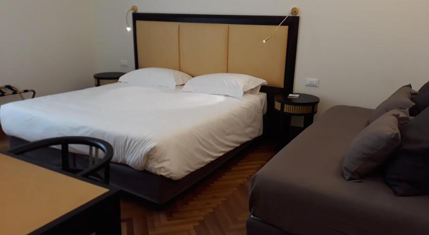 a hotel room with a bed, desk, and chair, Torrione Hotel in Reggio Calabria