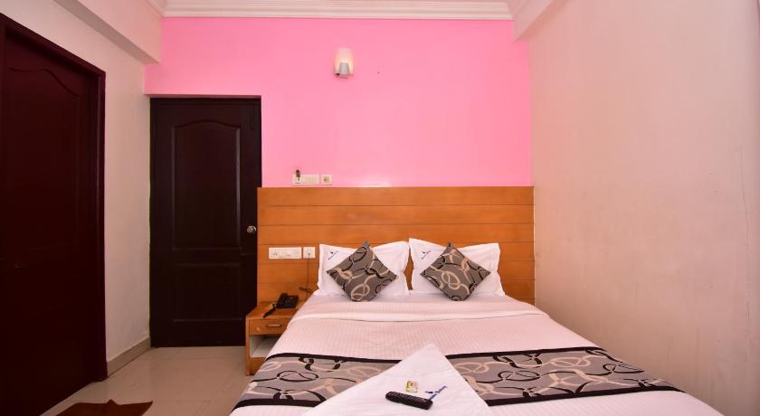 a bed room with a white bedspread and white sheets, Samudra Residency in Chennai