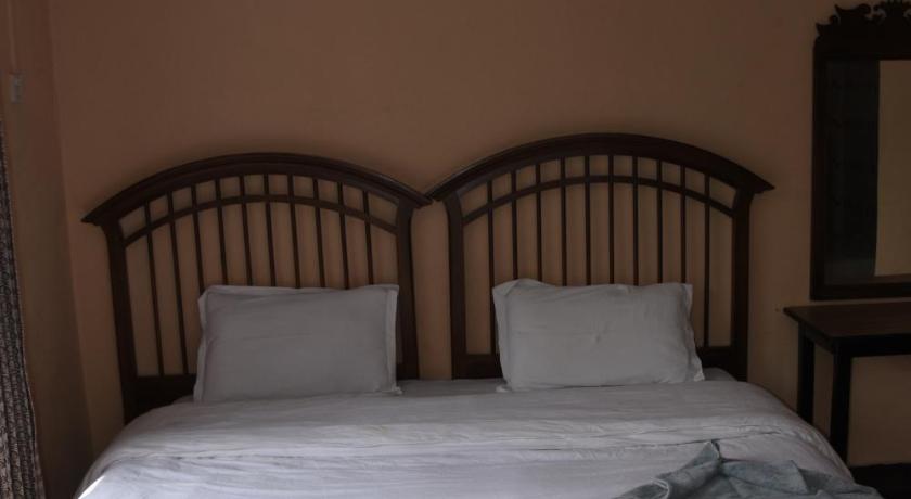 a bed with two white pillows and a white comforter, Family Peace House in Kathmandu