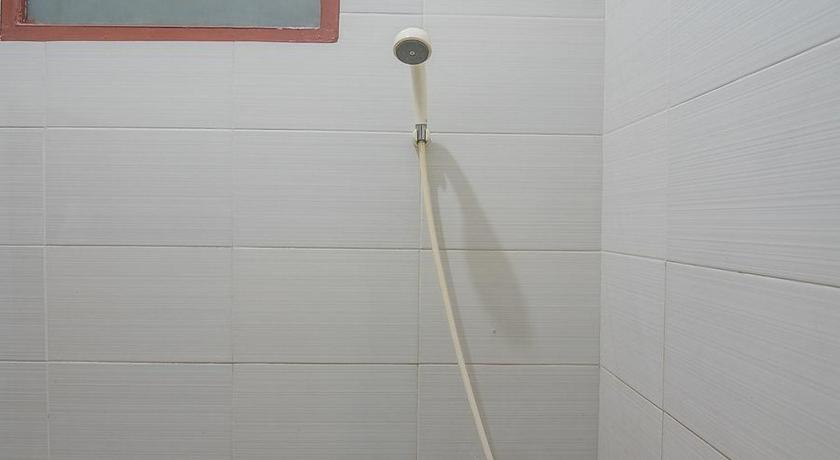 a white toilet sitting in a bathroom next to a wall, RedDoorz near Alun Alun Subang in Bandung