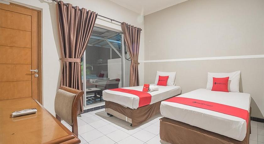 a hotel room with two beds and a couch, RedDoorz near Alun Alun Subang in Bandung