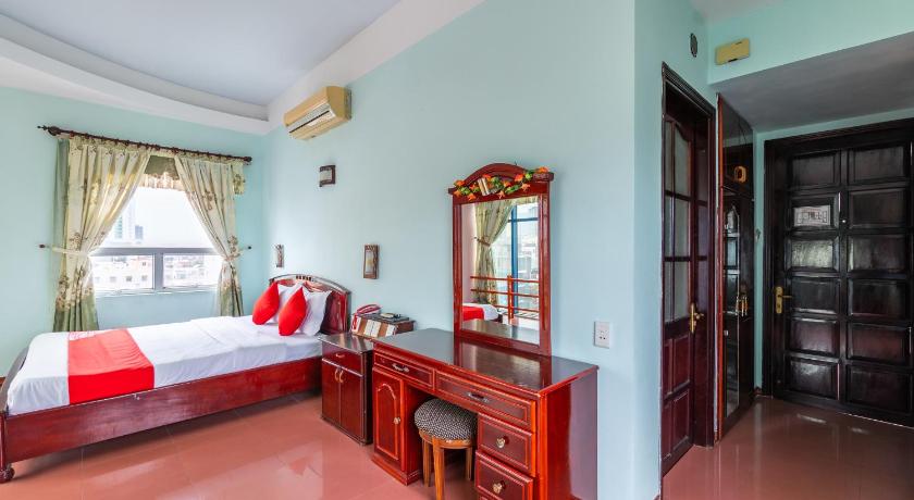 a bedroom with a large bed and a large window, OYO 266 Golden Gate in Da Nang