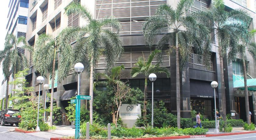a large building with palm trees and palm trees, The Infinity Tower Suites in Manila