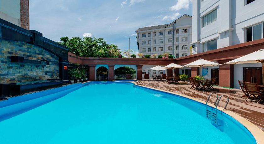 a swimming pool with a large blue umbrella, Lao Cai Star Hotel in Lao Cai City