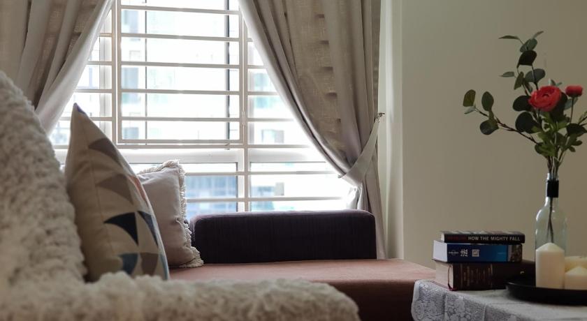 a cat sitting on a couch next to a window, SK Homestay Selayang Point Condo in Kuala Lumpur