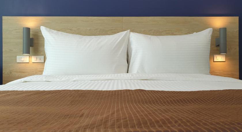 a bed with a white comforter and pillows, Leez Inn Makati in Manila