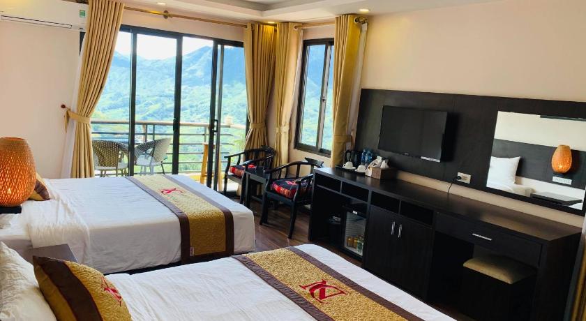 a hotel room with two beds and a television, Sapa Mountain Hotel in Sapa