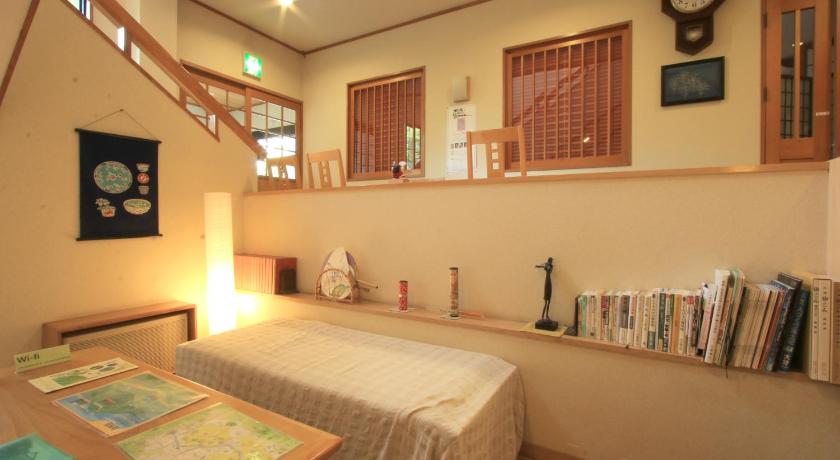 a room with a bed, a table, and a clock on the wall, Yufuin Yamaboushi                                                                                in Yufu