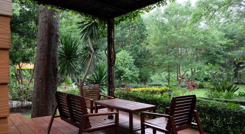 a wooden table and chairs in a wooded area, Moosiyard Hometel Khaoyai in Khao Yai
