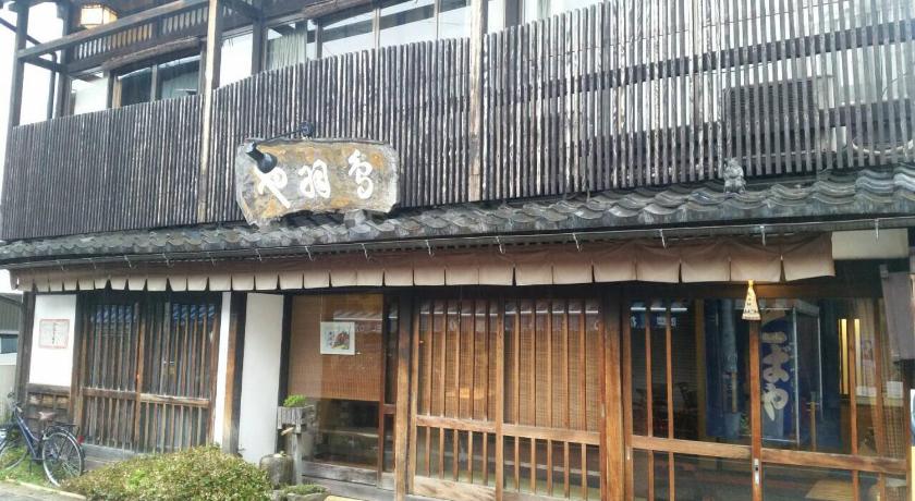an old building with a sign on the side of it, Tobaya Ryokan in Hikone