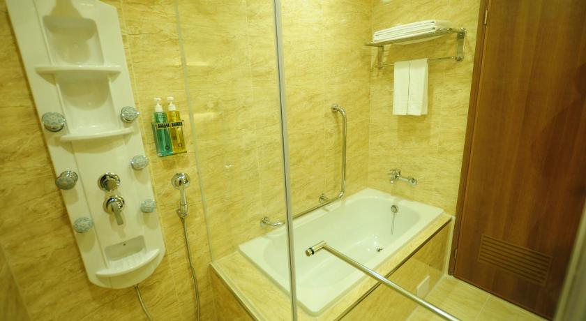 a bathroom with a tub, toilet and sink, Kindness Hotel Hualien in Hualien
