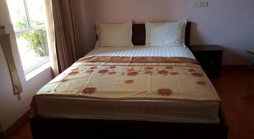 a bed with a white comforter and pillows, Hai Duong Guesthouse in Hoa Binh