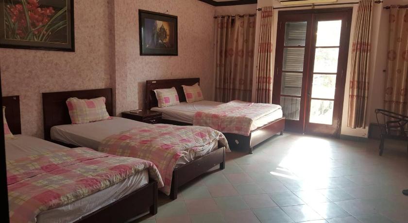 a bedroom with two beds and two windows, Hai Duong Hotel in Hoa Binh