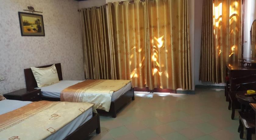 a bedroom with two beds and a window, Hai Duong Hotel in Hoa Binh