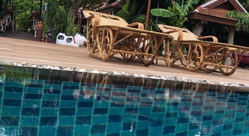 a white umbrella sitting on top of a wooden table, Montri Resort Donmuang Bangkok in Bangkok