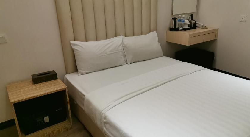 a hotel room with a bed and a desk, Ease Hotel in Kota Kinabalu
