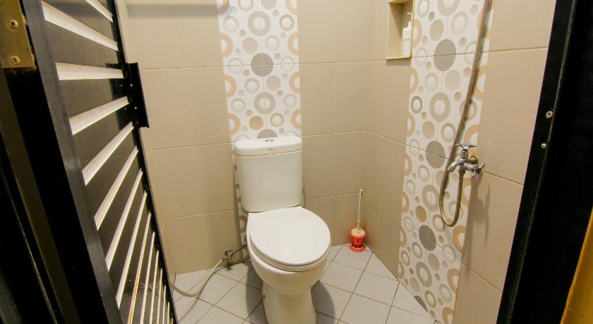 a bathroom with a toilet and a shower stall, Yani Homestay in Padang