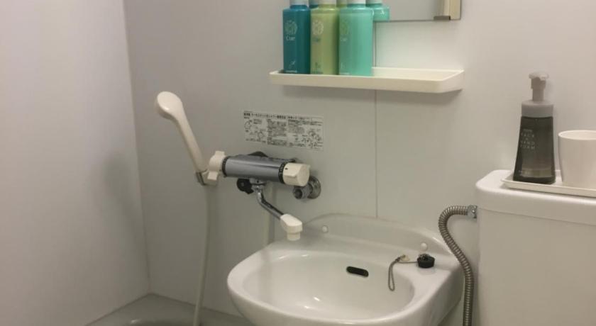 a bathroom with a sink, toilet, and bathtub, Ryokan Kamogawa Asakusa Hotel in Tokyo