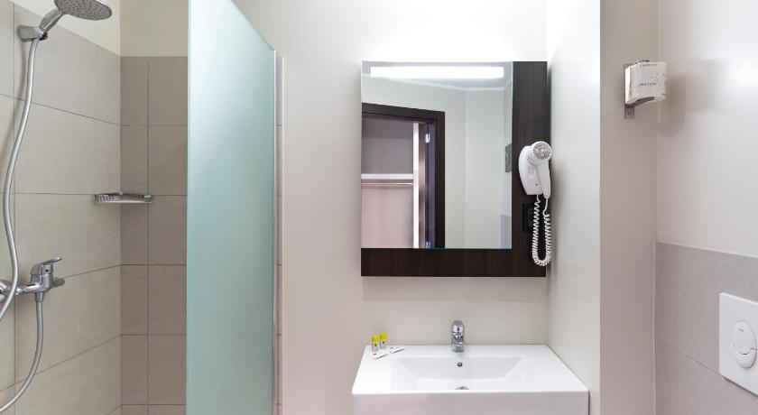 a bathroom with a shower, sink, and mirror, B&B Hotel Faenza in Faenza