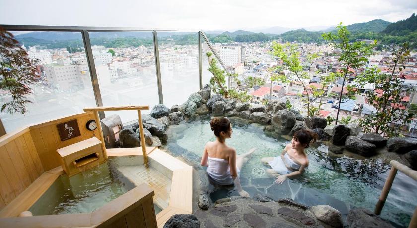 a man and a woman sitting in a pool of water, Takayama Ouan Hotel in Takayama