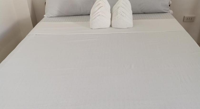 a white bed with white sheets and pillows, RMB GUEST HOUSE in Siquijor Island