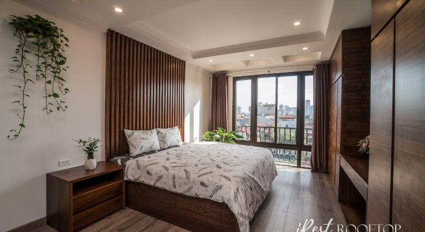 a bedroom with a large bed and a large window, IREST APARTMENT in Hanoi