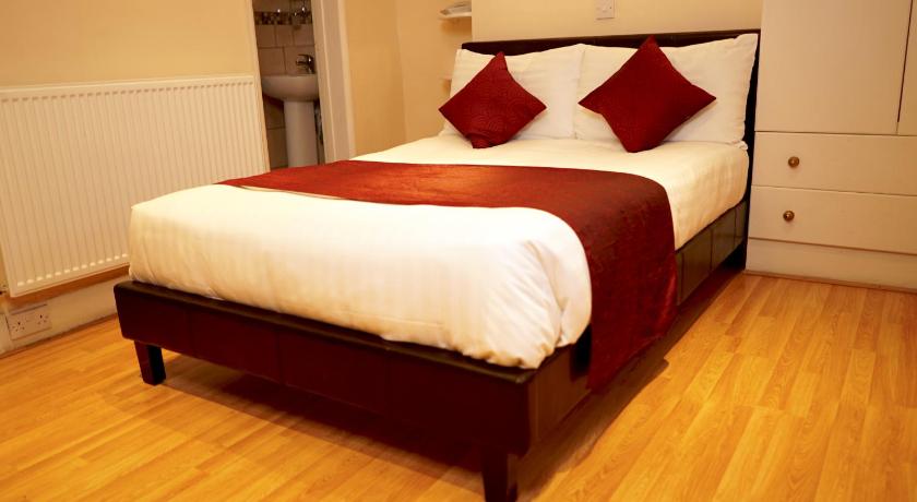 a neatly made bed in a small room, La Gaffe Hotel and Restaurant in London